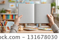 Little child hold in hands closed kids book with a blank front cover in nursery room. childhood and reading concept mockup 131678030