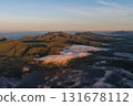 Aerial view of lofoten mountains emerging through clouds at sunrise 131678112