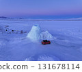 Red car exploring frozen ice geyser landscape at winter sunset, Kazakhstan 131678114