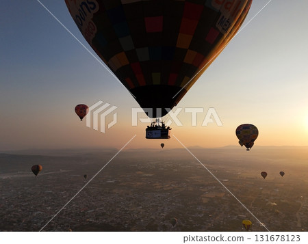 Hot air balloons flying over city at sunrise 131678123