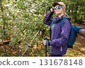 Happy woman hiker adjusting sunglasses during forest trekking 131678148