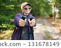 Female hiker showing trekking poles during outdoor adventure 131678149
