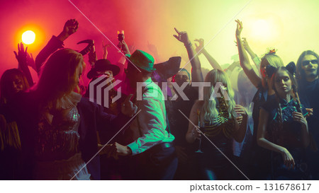 Crowd dancing with colorful lights in Halloween themed nightclub party atmosphere 131678617