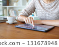 Woman hand touching tablet screen on table at home 131678948