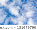Soft textured white clouds across vibrant blue sky, airy weather background with copy space for nature, freedom, travel, and optimism themes, minimal and serene. 131679790