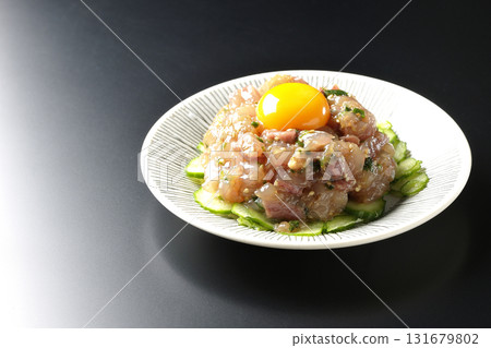 Spanish mackerel tartare photographed against a black background 131679802