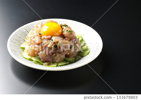 Spanish mackerel tartare photographed against a black background Spanish mackerel tartare photographed against a black background 131679803
