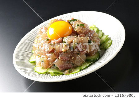 Spanish mackerel tartare photographed against a black background 131679805