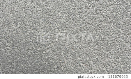 Surface texture of a gray concrete pavement displaying fine details and patterns under natural light 131679933