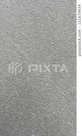 Textured gray surface showing subtle variations in tone and pattern under natural light Textured gray surface showing subtle variations in tone and pattern under natural light 131679934
