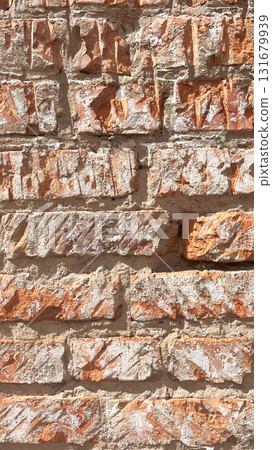 Textured orange and gray brick wall showcasing varying stone patterns and natural colors 131679939