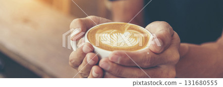 Banner Coffee barista pour espresso shot and make latte art hot coffee cup. Cappuccino with milk in italian coffee shop cafe. Banner Close up hands of barista make brown latte art with copy space 131680555