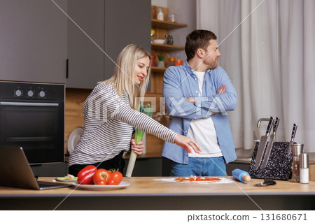Leave Me Alone. A woman is preparing food, and a man is talking to her, and is not satisfied with the way she is cooking. Leave Me Alone. A woman is preparing food, and a man is talking to her, and is not satisfied with the way she is cooking. 131680671