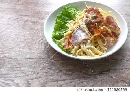 fried spaghetti white cabonara cream sauce topping slice crispy pork bacon and lettuce on plate  131680769
