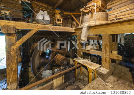 Historical Kvacany water mill interior showing machinery working Historical Kvacany water mill interior showing machinery working 131680893