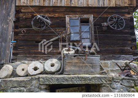 Old wooden house showing antique tools and millstones in Sekowa 131680904