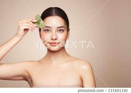 Young woman doing scrapping massage facial skin Young woman doing scrapping massage facial skin 131681192