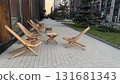 Wooden lounge chairs and small table on urban sidewalk at sunset, perfect for outdoor relaxation background 131681343