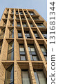 Modern architectural building with geometric brick facade and large windows reaching skyward 131681344