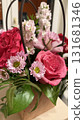 Bouquet of pink and red flowers with green leaves in decorative basket indoors 131681346