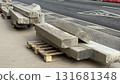Concrete slabs on wooden pallets stacked on a sidewalk for construction or urban development 131681348