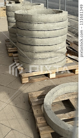 Concrete rings stacked on wooden pallets at construction site in outdoor setting Concrete rings stacked on wooden pallets at construction site in outdoor setting 131681349