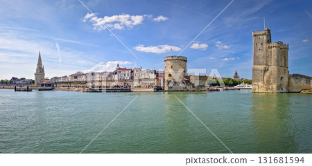 Panoramic view of the iconic entrance to the Vieux Port of La Rochelle, France. Panorama of all three medieval towers guarding the marina, the Tour Saint-Nicolas near the chain and the lantern towers Panoramic view of the iconic entrance to the Vieux Port of La Rochelle, France. Panorama of all three medieval towers guarding the marina, the Tour Saint-Nicolas near the chain and the lantern towers 131681594