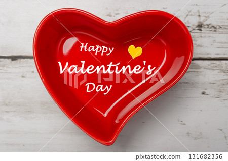 A bright red heart-shaped cocotte dish and an antique wood-grain table 131682356