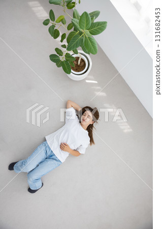 一名年輕女子仰臥在地板上，放鬆 131682453