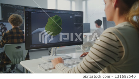 Female Student Creates 3D Model on Computer in Modern Classroom 131682540