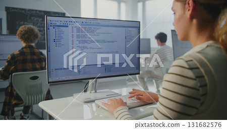 In Game Dev Workshop, Young Woman Typing Program Code on Monitor In Game Dev Workshop, Young Woman Typing Program Code on Monitor 131682576