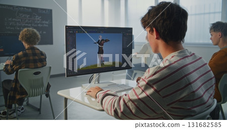 Student in Striped Sweatshirt Creates 3D Animation on Computer in Modern Classroom Student in Striped Sweatshirt Creates 3D Animation on Computer in Modern Classroom 131682585