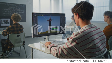 Student in Striped Sweatshirt Creates 3D Animation on Computer in Modern Classroom Student in Striped Sweatshirt Creates 3D Animation on Computer in Modern Classroom 131682589