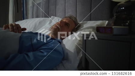 Middle Aged Man Wakes Up Early in Morning in Bedroom Filled With Sunlight 131682616