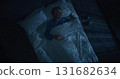 White Haired Man in Blue Pajamas Enters Bedroom and Lies Down on Bed 131682634