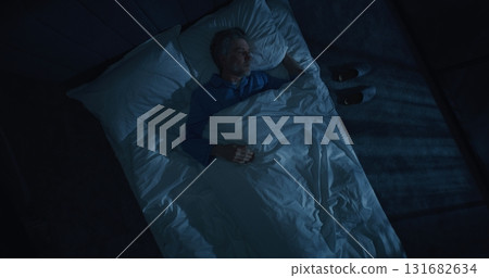 White Haired Man in Blue Pajamas Enters Bedroom and Lies Down on Bed White Haired Man in Blue Pajamas Enters Bedroom and Lies Down on Bed 131682634