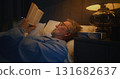 Mature Man Wearing Glasses Reads in Bed Few Hours Before Dawn 131682637