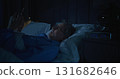 Handsome Gray Haired Man With Beard Laughs and Scrolls Through Social Media at Night 131682646
