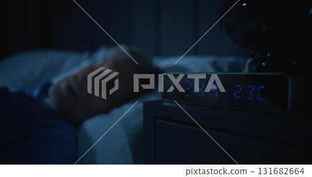 Restless Man in Dark Bedroom, Digital Clock Glowing at Two AM Restless Man in Dark Bedroom, Digital Clock Glowing at Two AM 131682664