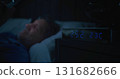 Mature Man in Bed Illuminated By Smartphone Screen, Digital Clock Showing Two AM 131682666