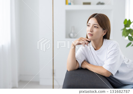 沉思的年輕女子坐在沙發上 131682787