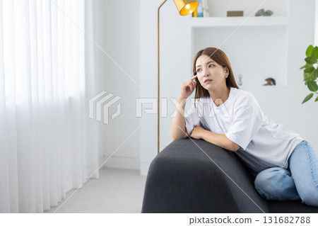 沉思的年輕女子坐在沙發上 131682788