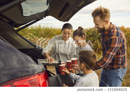 Happy mother, father and children make a stop to drink tea during their road trip Happy mother, father and children make a stop to drink tea during their road trip 131684020
