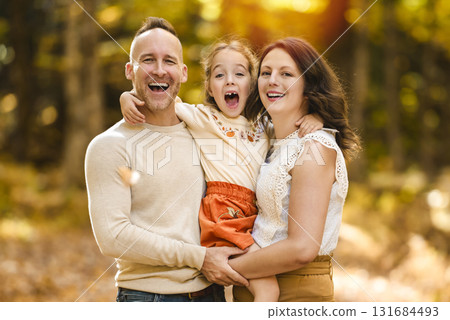 Mature family with daughter on a walk in autumn forest. 131684493