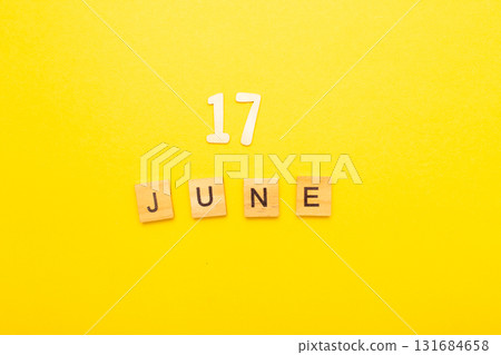 Top view of word 17 June calendar date made by wooden cubes on yellow color background 131684658