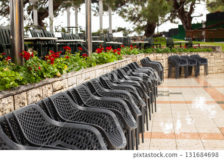 Empty chairs and tables in outdoor restaurant setting waiting for customers 131684698