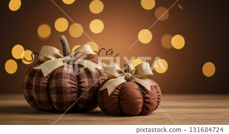Handmade fabric pumpkins with burlap bows on a wooden table. DIY decor for autumn and Thanksgiving holidays. 131684724