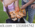 Happy family preparing barbecue in the garden together outdoor. 131684742
