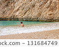 Child sitting at the seashore on summer holiday trip. Travel concept. 131684749