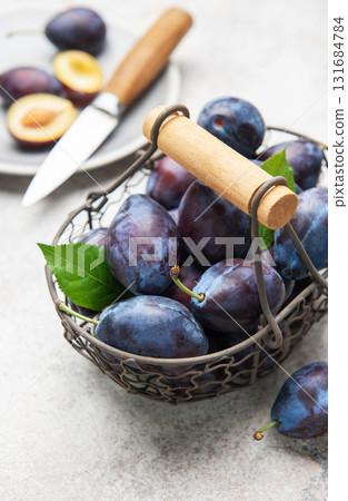Fresh plums in basket with sliced fruit Fresh plums in basket with sliced fruit 131684784